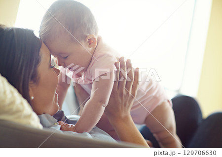Mom, bonding or forehead touch with baby girl on house living room, relax nursery or family home sofa in trust or love. Smile, happy or infant child playing mother in support, security or relax game Mom, bonding or forehead touch with baby girl on house living room, relax nursery or family home sofa in trust or love. Smile, happy or infant child playing mother in support, security or relax game 129706630