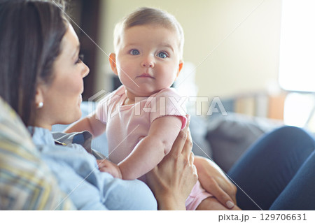 Woman, bonding and mother with baby girl on house living room, nursery or family home sofa in trust, support or love. Curious, infant and child with mom in relax, security or safety comfort on couch Woman, bonding and mother with baby girl on house living room, nursery or family home sofa in trust, support or love. Curious, infant and child with mom in relax, security or safety comfort on couch 129706631