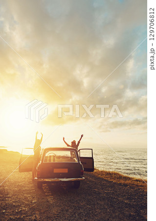 Travel, car and couple of friends with sunset road trip, journey and freedom for summer holiday celebration. Celebrate, vintage and retro women rear with transport for adventure, parking and ocean 129706812
