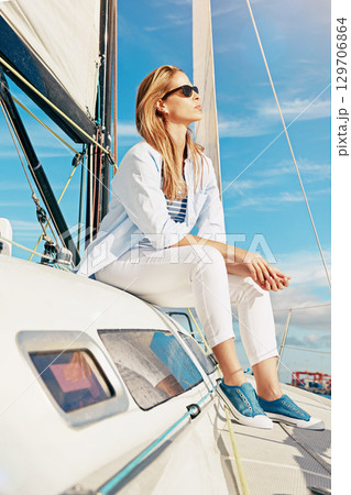 Fashion, travel and woman on yacht in ocean for holiday, summer vacation and weekend getaway in Italy. Travelling lifestyle, adventure and lady with sunglasses smile, relax and freedom on boat trip 129706864
