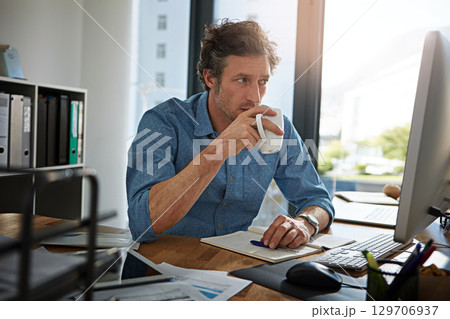 Coffee, thinking and computer with a business man at work in his office for future growth or research. Idea, tea and internet with a male employee working or planning online using a desktop Coffee, thinking and computer with a business man at work in his office for future growth or research. Idea, tea and internet with a male employee working or planning online using a desktop 129706937