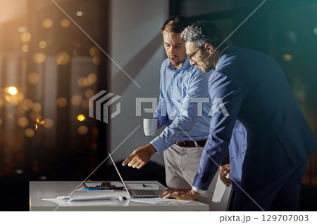 Teamwork, review and night with business people at laptop for project management, planning or web design. Collaboration, goal and documents with employee in digital agency for marketing strategy 129707003