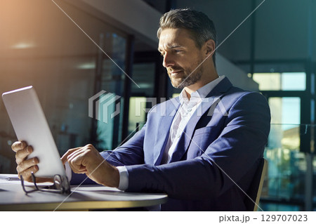 Business man, tablet and working ceo financial worker planning with web finance analytics. Office, senior investment employee and boss typing a tech strategy report for a stock market growth company 129707023