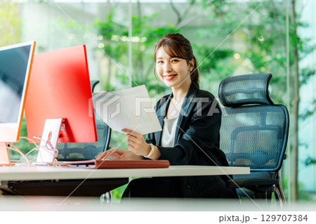 オフィスでパソコンを操作する若いビジネスウーマン 129707384