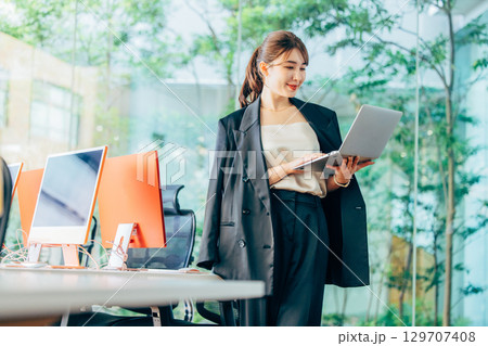 オフィスでパソコンを操作するビジネスウーマン 129707408
