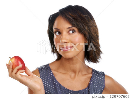 Fruit, thinking or black woman eating an apple in studio on white background with marketing mockup space. Choices, ideas or thoughtful African girl advertising a healthy natural diet for wellness 129707605