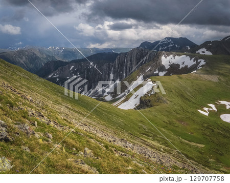 Green vegetation and stones on grassy slope 129707758
