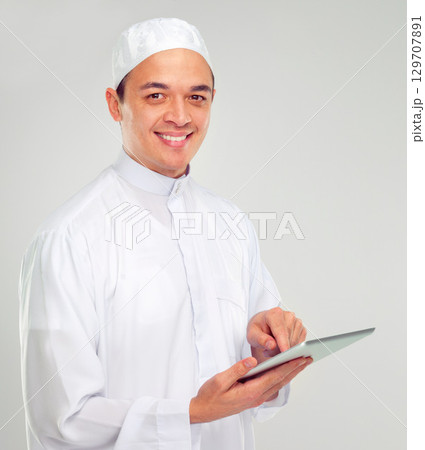 Islamic man, tablet and happy portrait for Muslim reading, education or culture standing in white background. Young person, smile and digital tech learning for religious mindset isolated in studio Islamic man, tablet and happy portrait for Muslim reading, education or culture standing in white background. Young person, smile and digital tech learning for religious mindset isolated in studio 129707891