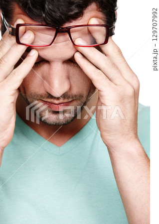 Mental health, depression and face of studio man with anxiety problem, burnout fatigue and depressed over mistake. Medical healthcare crisis, headache and sad model with migraine on white background 129707992