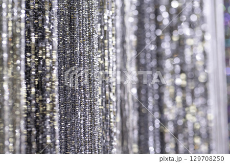 Shimmering silver strands create a dazzling backdrop with reflections and soft bokeh effects 129708250