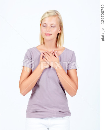 Peace, calm and woman with hands on heart for love, worship and gratitude on a white background. Happy, grateful and girl praying for religion or listening to heartbeat on a studio background 129708740