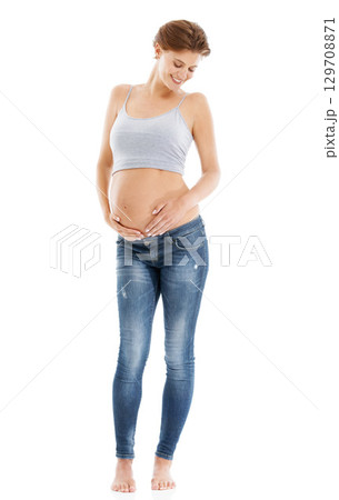Body of a pregnant woman in studio on a white background happy with pregnancy health, growth and development. Healthcare, wellness and an excited mother, hand holding stomach with advertising mockup Body of a pregnant woman in studio on a white background happy with pregnancy health, growth and development. Healthcare, wellness and an excited mother, hand holding stomach with advertising mockup 129708871