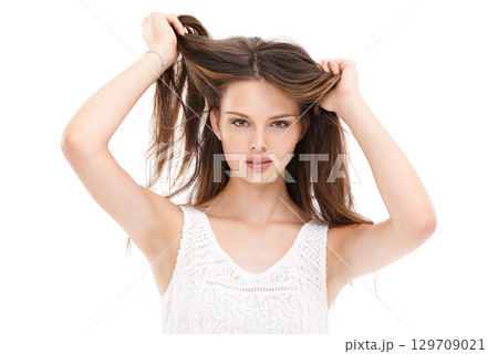 Portrait, hair and beauty with a model woman in studio on a white background for keratin treatment at a salon. Face, haircare and natural aesthetic with a young female holding her straigh hair 129709021