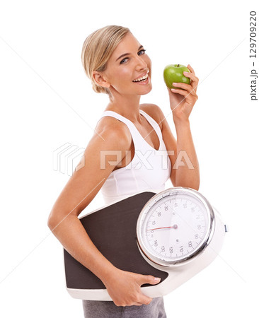 Woman, apple and carrying scale for diet, weight loss or healthy nutrition against a white background. Portrait of happy isolated female with smile for organic, vitamins and dieting food for measure Woman, apple and carrying scale for diet, weight loss or healthy nutrition against a white background. Portrait of happy isolated female with smile for organic, vitamins and dieting food for measure 129709220