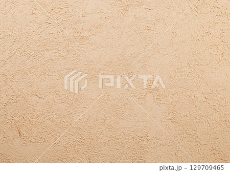 Wall with a tan color and a rough texture 129709465