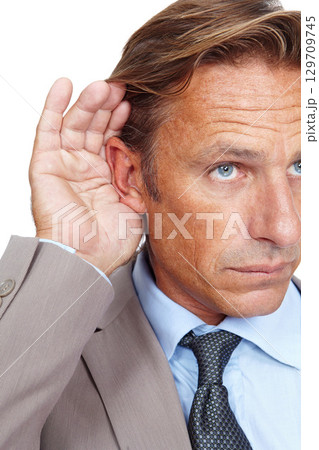 Hear, secret and businessman holding his ear in a studio while listening to a whisper conversation. Communication, listen and corporate male model hearing a discussion isolated by a white background. Hear, secret and businessman holding his ear in a studio while listening to a whisper conversation. Communication, listen and corporate male model hearing a discussion isolated by a white background. 129709745