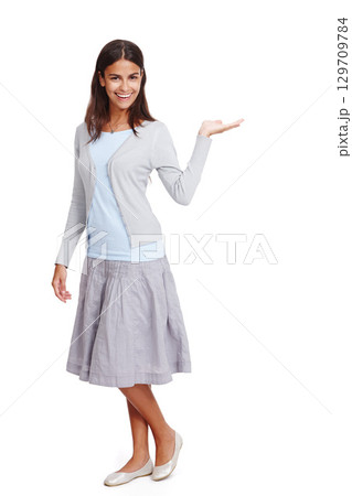 Happy, casual and woman with product mockup in a studio for placement, marketing or advertising. Fashion, portrait and female model weighing mock up space with her hand isolated by a white background 129709784