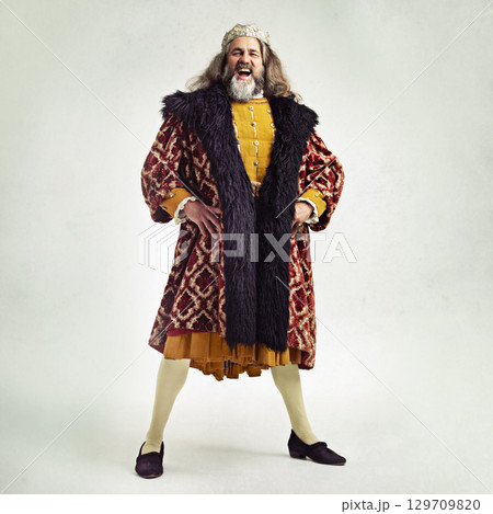 King, crown and portrait with a royal man in studio on a gray background during the renaissance period of history. Medieval, victorian and royalty with a male ruler posing as leader of his kingdom 129709820