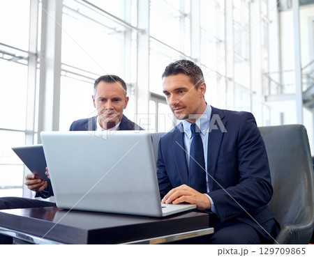 Corporate, laptop and business people in lobby meeting, collaboration or strategy planning on global marketing. Professional businessman, client or partner reading online review for company portfolio 129709865