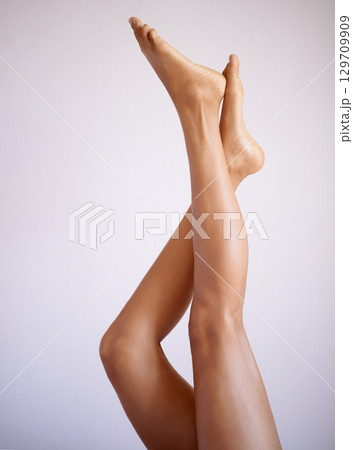 Legs, beauty and skin with a model black woman posing in studio on a gray background for skincare treatment. Fitness, spa and feet with a female isolated indoors for natural care or luxury wellness Legs, beauty and skin with a model black woman posing in studio on a gray background for skincare treatment. Fitness, spa and feet with a female isolated indoors for natural care or luxury wellness 129709909
