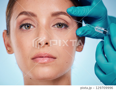Plastic surgery, skincare and woman with injection, healthcare and on blue studio background. Female, girl and fillers with cosmetics, wellness and face care for health, soft and smooth skin for beau Plastic surgery, skincare and woman with injection, healthcare and on blue studio background. Female, girl and fillers with cosmetics, wellness and face care for health, soft and smooth skin for beau 129709996