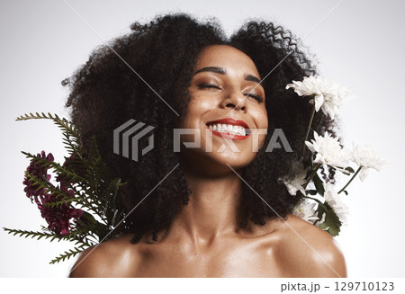 Black woman, beauty and flowers on studio background for healthy skincare. Happy face, floral plants and model with spring perfume, natural makeup and eco wellness for cosmetics, aesthetics and smile Black woman, beauty and flowers on studio background for healthy skincare. Happy face, floral plants and model with spring perfume, natural makeup and eco wellness for cosmetics, aesthetics and smile 129710123