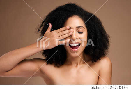 Hand, face and surprise with black woman and beauty, hair care with shine and skincare with healthy skin glow. Natural curly hair, manicure and cosmetic care with facial against studio background 129710175