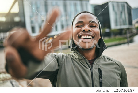Fitness, selfie and portrait of a black man with peace sign in the city doing a cardio exercise. Happy, smile and real African guy taking picture while running for sports, race or marathon training. Fitness, selfie and portrait of a black man with peace sign in the city doing a cardio exercise. Happy, smile and real African guy taking picture while running for sports, race or marathon training. 129710187