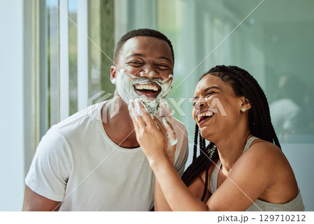 Skincare wellness, happy couple in bathroom and shaving face with product for facial treatment. Laughing together in home, natural beauty and funny girlfriend helping black man with cream application Skincare wellness, happy couple in bathroom and shaving face with product for facial treatment. Laughing together in home, natural beauty and funny girlfriend helping black man with cream application 129710212