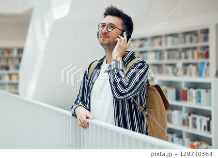 Headphones, college student man and university library work or research for learning. School campus building, music and live song streaming of a person looking for study books Headphones, college student man and university library work or research for learning. School campus building, music and live song streaming of a person looking for study books 129710363