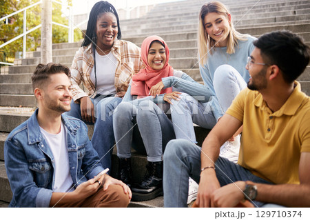 Relax, happy or students on steps at break talking or speaking of future goals or education. Diversity, school or funny friends in university laughing or bonding in conversation on college campus 129710374