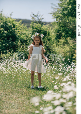 Girl Daisies Field: Child with flower crown in meadow on sunny day, enjoying summer beauty/ nature. Girl Daisies Field: Child with flower crown in meadow on sunny day, enjoying summer beauty/ nature. 129710668
