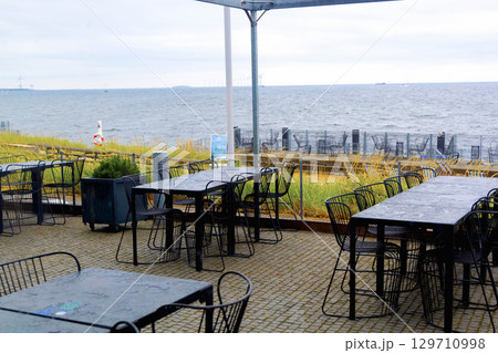A deserted cafe by the sea on a cloudy day. 129710998