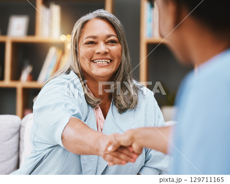 Handshake, healthcare and appointment with a senior woman shaking hands with a female nurse in a retirement home. Thank you, medical and meeting with a mature patient and medicine professional 129711165