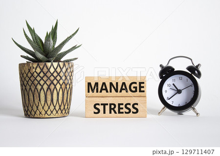 Manage stress symbol. Concept word Manage stress on wooden blocks. Beautiful white background with alarm clock and succulent plant. Business and Manage stress concept. Copy space Manage stress symbol. Concept word Manage stress on wooden blocks. Beautiful white background with alarm clock and succulent plant. Business and Manage stress concept. Copy space 129711407