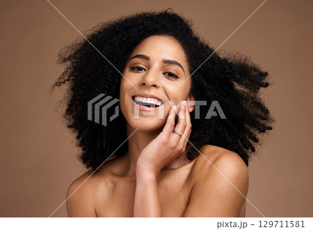 Woman, studio portrait and afro with beauty, makeup and cosmetic wellness with hands, face or natural hair. Model, skincare and facial cosmetics, self care glow and smile by brown studio background Woman, studio portrait and afro with beauty, makeup and cosmetic wellness with hands, face or natural hair. Model, skincare and facial cosmetics, self care glow and smile by brown studio background 129711581