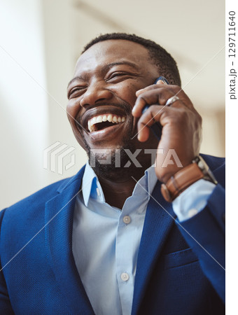 Phone call, communication and laughing with a business black man talking while working in corporate. Mobile, networking or management with a male CEO feeling happy while chatting on his smartphone 129711640