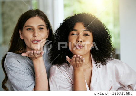 Women portrait, friends and blowing kisses in home, house or hotel bathroom for bonding holiday, skincare or grooming. Smile, happy and people face with blow gesture in relax spa or luxury treatment 129711699