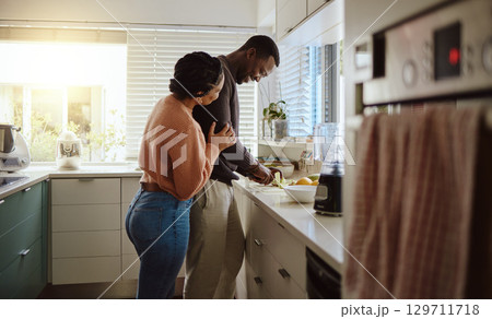 Black couple, cooking and helping with food in kitchen at home while together to cook healthy food. Happy young man and woman in their house or apartment to bond and prepare lunch or dinner with love Black couple, cooking and helping with food in kitchen at home while together to cook healthy food. Happy young man and woman in their house or apartment to bond and prepare lunch or dinner with love 129711718