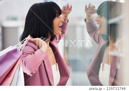 Excited woman, window shopping and mall for retail therapy, sale or customer discount at a store. Paper bag, fashion and female happy about clothes, promotion or commerce product during travel Excited woman, window shopping and mall for retail therapy, sale or customer discount at a store. Paper bag, fashion and female happy about clothes, promotion or commerce product during travel 129711746
