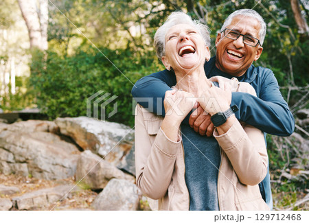 Hiking, laugh and romance with a senior couple hugging while in the woods or nature forest together in summer for a hike. Fun, joke and bonding with a mature man and woman enjoying retirement outdoor Hiking, laugh and romance with a senior couple hugging while in the woods or nature forest together in summer for a hike. Fun, joke and bonding with a mature man and woman enjoying retirement outdoor 129712468