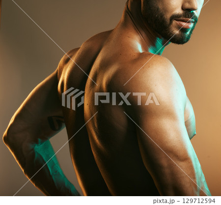 Man, body or back muscles on studio background with creative light aesthetic, training goals or workout progress. Zoom, skin or bodybuilder fitness model for healthcare wellness or exercise strength 129712594