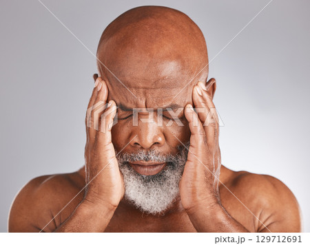 Elderly black man, headache and pain with hands and face, stress and mental health against studio background. Depression, skin and senior with healthcare problem, retirement and anxiety migraine 129712691