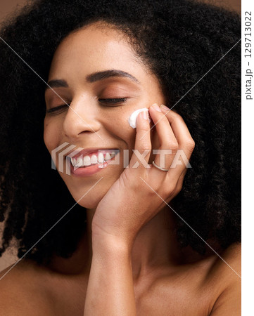 Black woman, skincare and cream for face, makeup and sunscreen product for wellness, luxury beauty and salon cosmetics. Happy model, facial lotion and natural dermatology, aesthetic and healthy glow Black woman, skincare and cream for face, makeup and sunscreen product for wellness, luxury beauty and salon cosmetics. Happy model, facial lotion and natural dermatology, aesthetic and healthy glow 129713022
