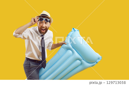 Happy excited businessman with inflatable water mattress having fun on summer holiday 129713038
