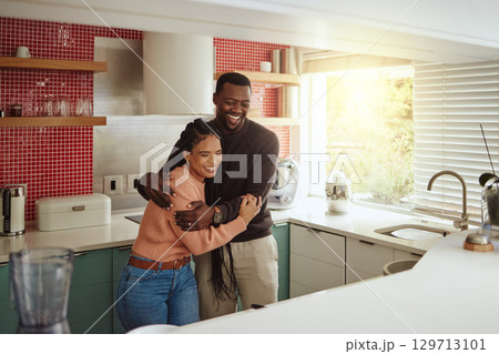 Black couple, happy home and love while together with care and happiness in a marriage with commitment and care. Young man and woman laughing while in the kitchen to bond in their house or apartment 129713101
