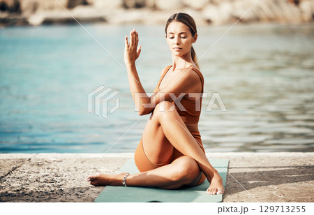 Fitness, yoga and zen, woman at beach stretching for meditation and training in nature for healthy lifestyle. Health, wellness and workout for girl at ocean, pilates exercise for balance at sea water 129713255
