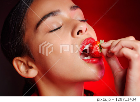 Face, eating and woman with red strawberry for fruit detox, health wellness goals or nutritionist diet. Lipstick makeup, erotic. beauty and sexy model girl with food product, skincare and cosmetics Face, eating and woman with red strawberry for fruit detox, health wellness goals or nutritionist diet. Lipstick makeup, erotic. beauty and sexy model girl with food product, skincare and cosmetics 129713434