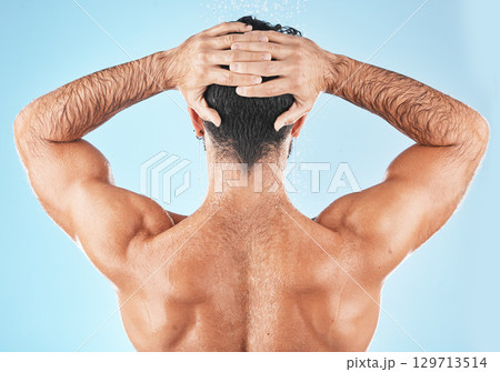 Water splash, man hair and shower for body hygiene, skincare grooming or cleaning care in blue background studio. Model back, self care water cleansing and cosmetics hair care wellness in morning Water splash, man hair and shower for body hygiene, skincare grooming or cleaning care in blue background studio. Model back, self care water cleansing and cosmetics hair care wellness in morning 129713514