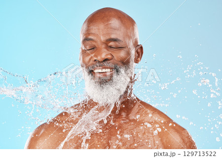 Relax, senior and black man with skincare cleaning routine and satisfied face with water splash. Mature cosmetic model washing body with smile for grooming hygiene on blue studio background. 129713522